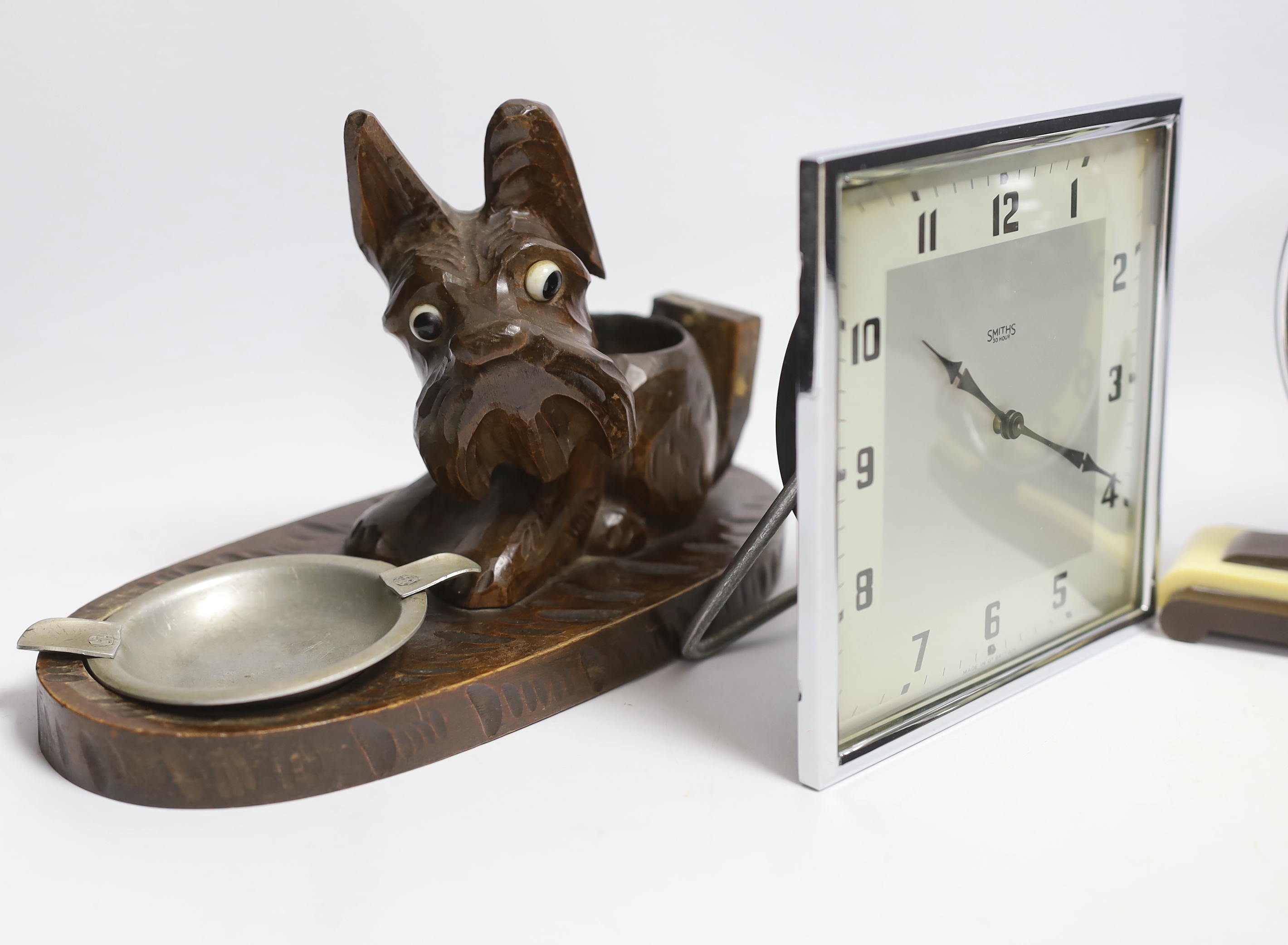 Two Art Deco clocks and two carved wood ‘dog’ ash trays, tallest 18cm